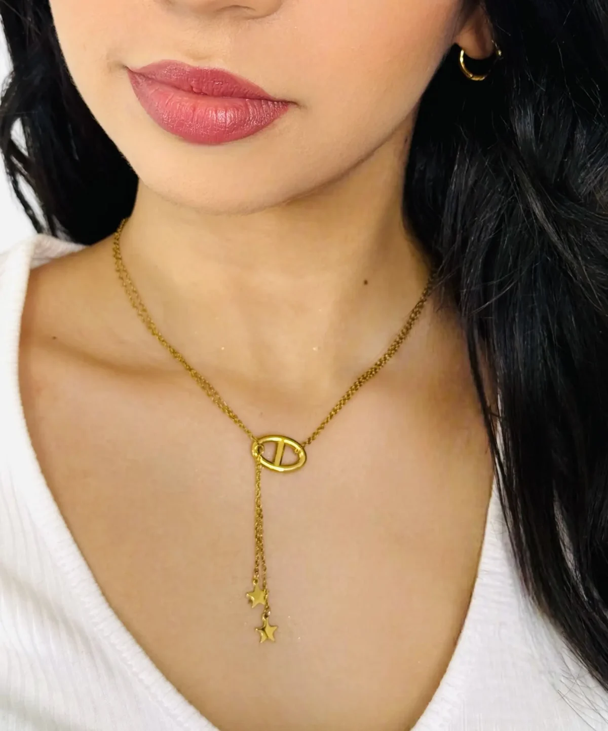 a woman wearing a necklace and earrings