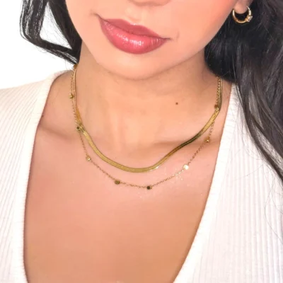 a woman wearing a white shirt and gold necklace