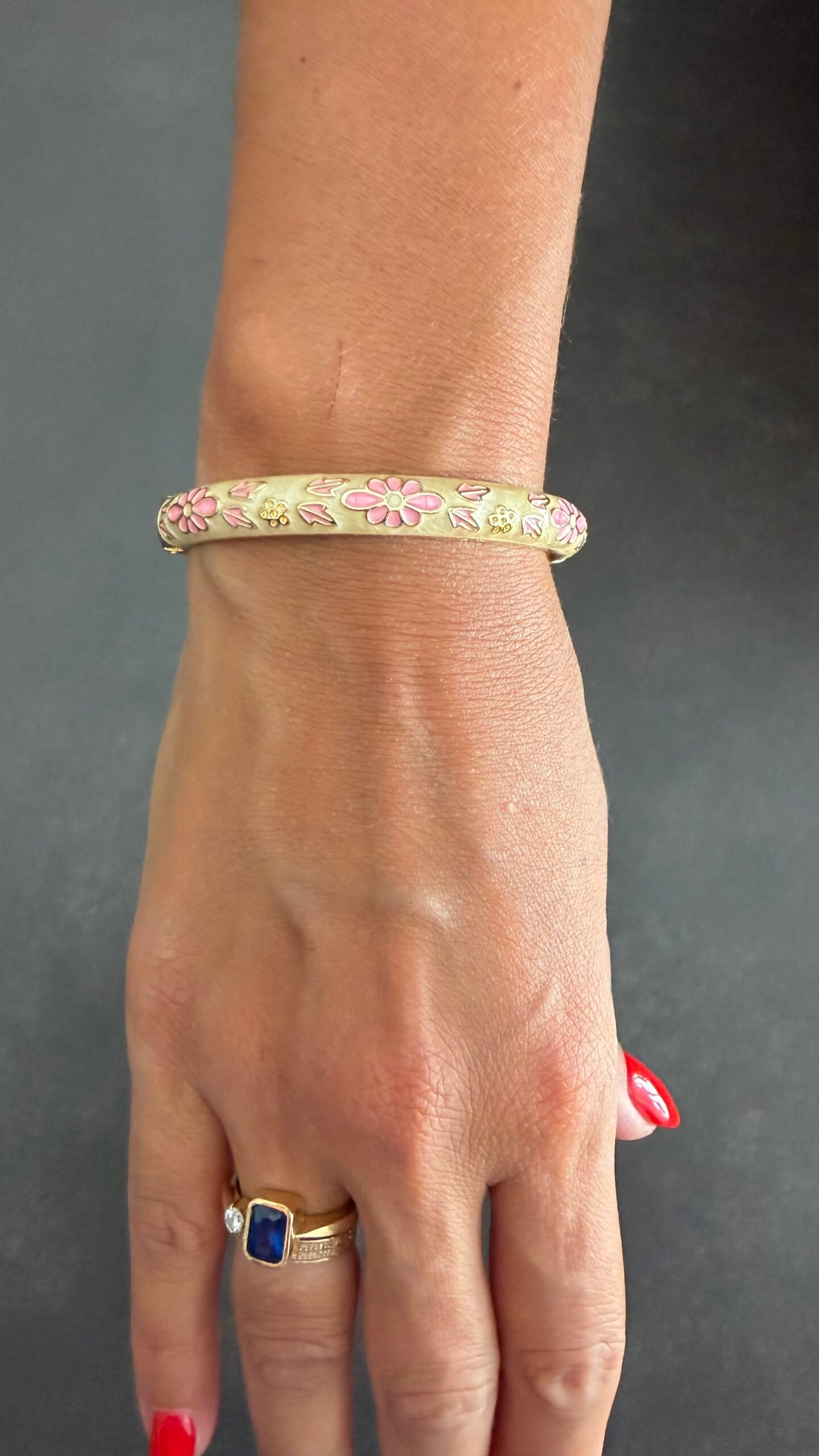 Bracelet Jonc Émaillé Fleurs Roses 4 Bracelet jonc émaillé ivoire à fleurs roses porté au poignet, acier inoxydable doré