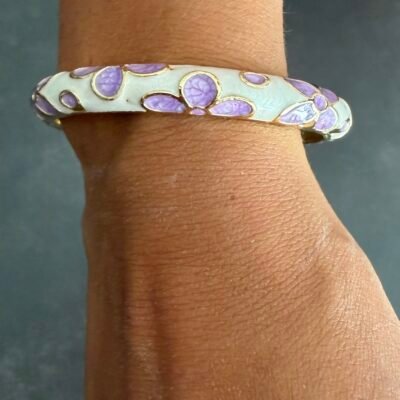 Bracelet jonc émaillé mauve à fleurs lilas porté au poignet, acier inoxydable doré