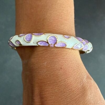 Bracelet jonc émaillé mauve à fleurs lilas porté au poignet, acier inoxydable doré