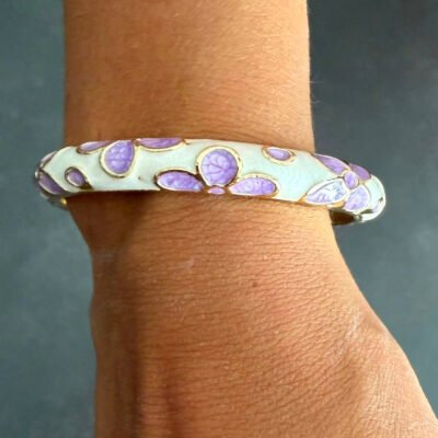 Bracelet jonc en laiton doré émaillé mauve à fleurs lilas porté au poignet