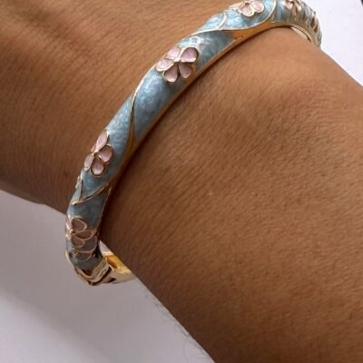Bracelet jonc émaillé turquoise à fleurs roses porté au poignet