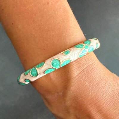 Bracelet jonc en laiton doré émaillé vert d’eau à fleurs porté au poignet