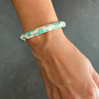 Bracelet jonc émaillé vert d'eau au poignet, fleurs en émail et finition dorée