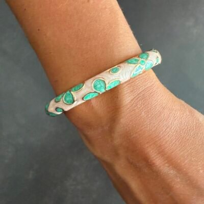 Bracelet jonc émaillé vert d'eau à fleurs porté au poignet, acier inoxydable doré