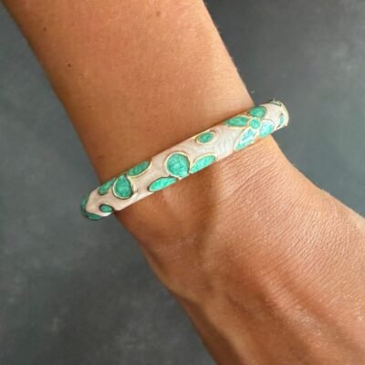 Bracelet jonc émaillé vert d'eau à fleurs porté au poignet, acier inoxydable doré