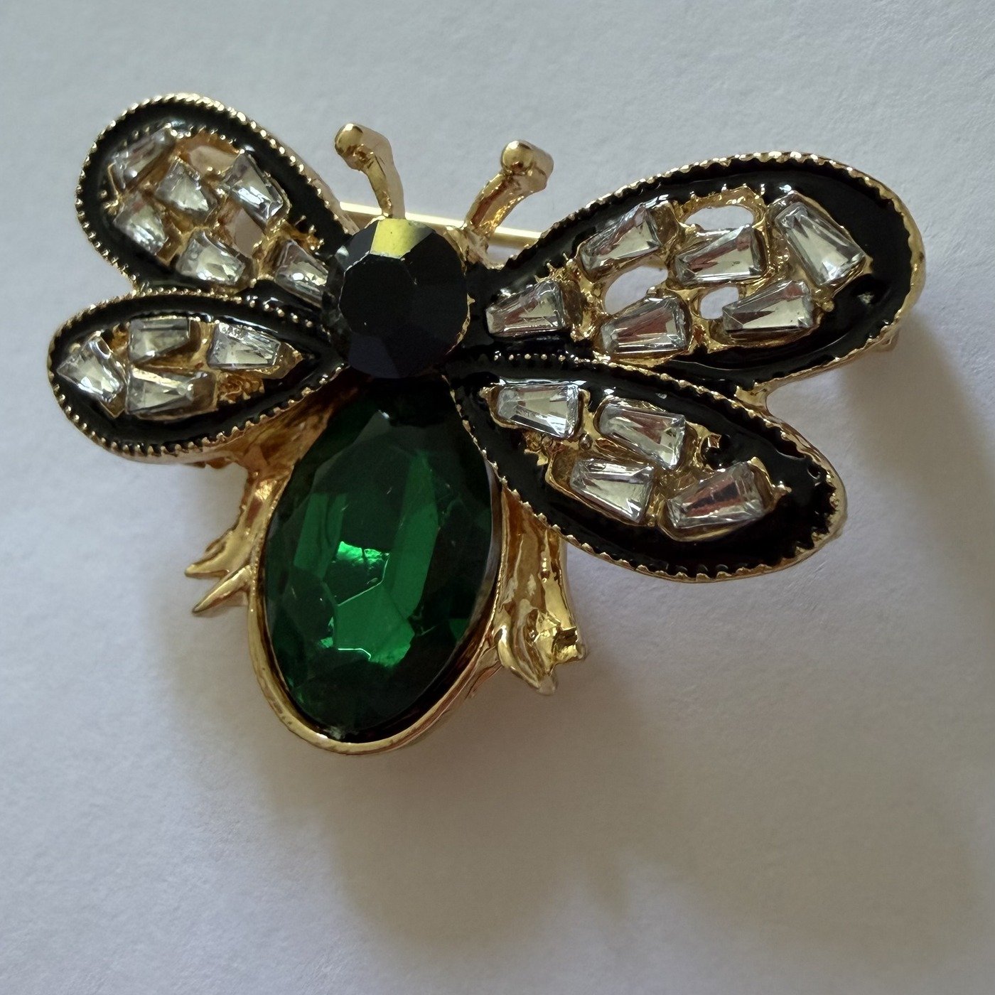 Broche Abeille Dorée Pierre Verte 3 Détail des ailes noires serties de strass baguette de la broche abeille dorée ChicConnect