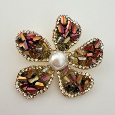 Broche fleur strass dorée vue de face, liseré de strass transparents cernant chacun des cinq pétales