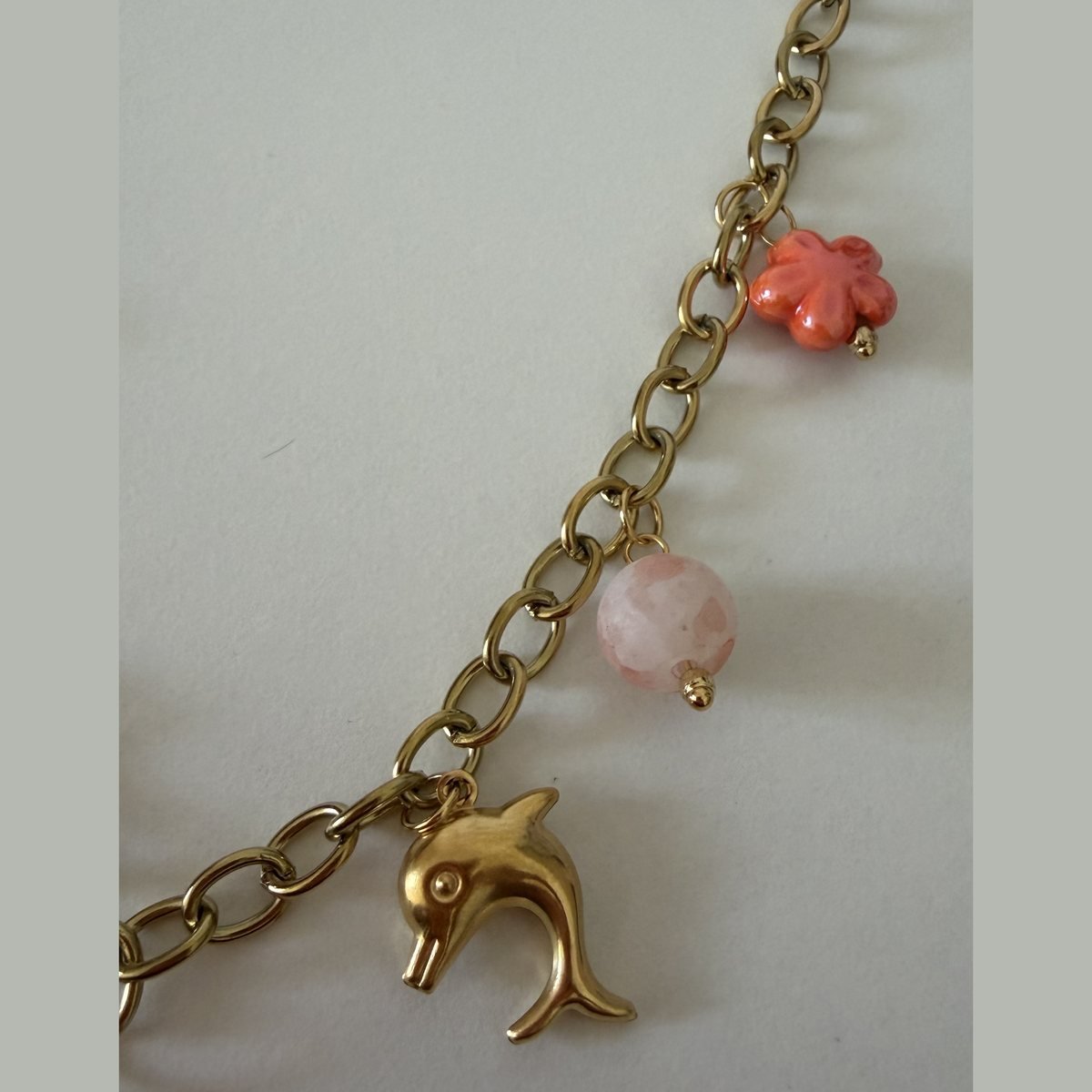 Collier Dauphin et Étoile de Mer Dorée 3 Breloque dauphin dorée et perle de quartz rose sur la chaîne du collier