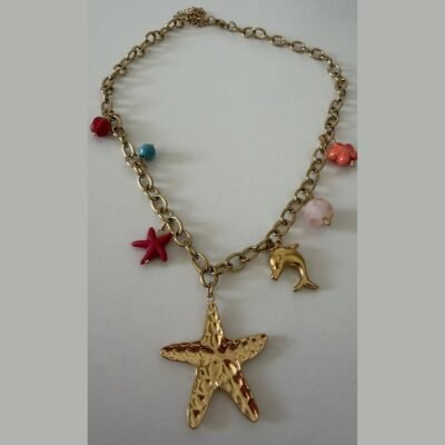 Collier doré à breloques marines : grande étoile de mer martelée, dauphin et perles corail