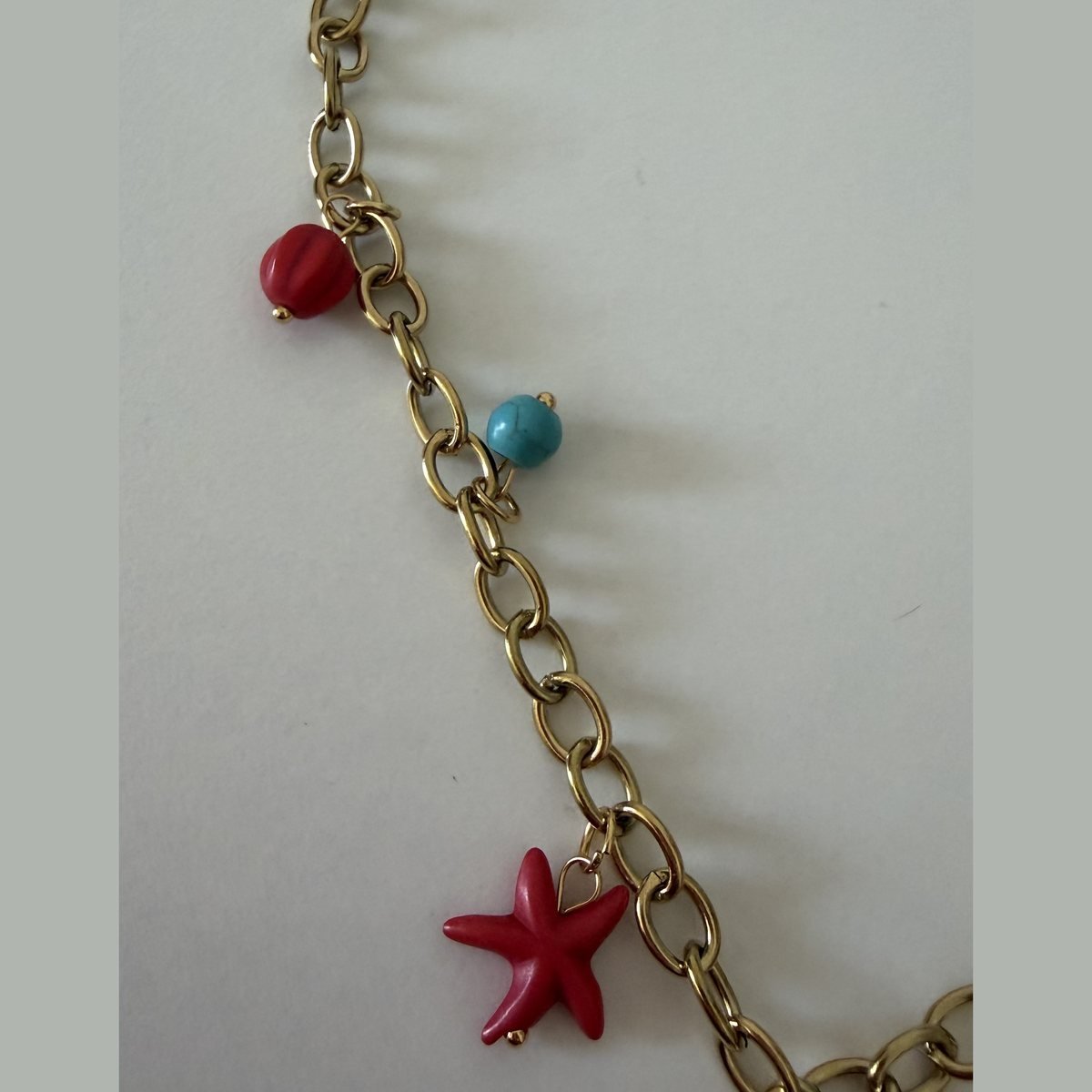 Collier Dauphin et Étoile de Mer Dorée 4 Perles corail rouge, turquoise et étoile de mer rouge sur le collier doré