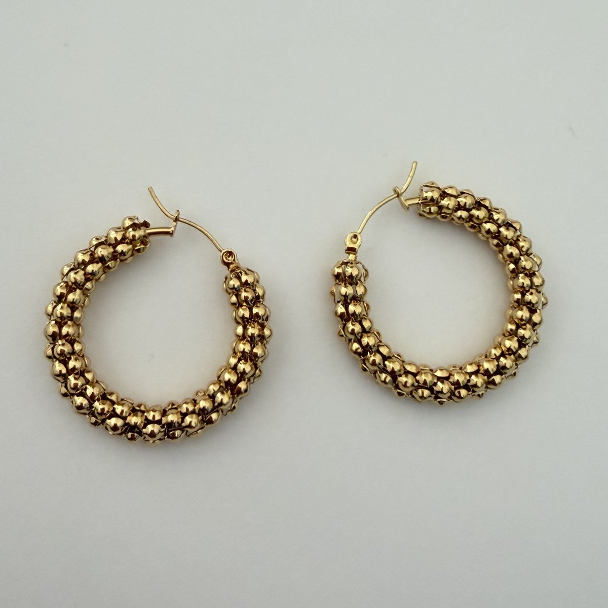 Créoles Dorées Maille Perlée 2 Paire de créoles dorées posées à plat, fermoir à charnière visible sur chaque créole