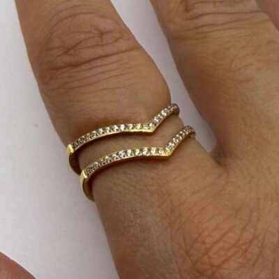Bague chevron double V dorée portée au majeur