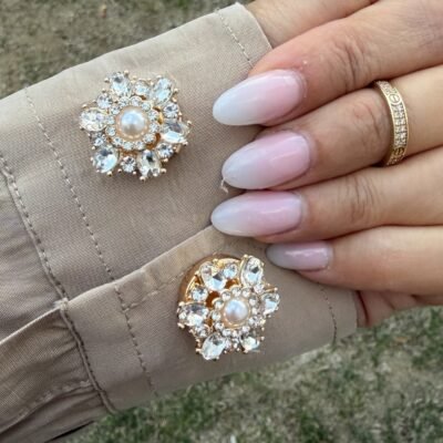 Paire de couvre-boutons fleur cristaux et perle portée sur une chemise beige