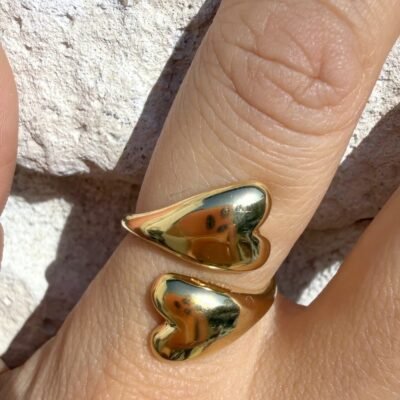 Bague ouverte deux coeurs bombés dorée portée, gros plan sur la main