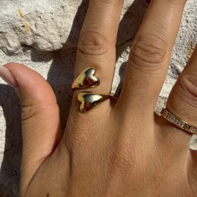 Bague coeurs bombés dorée portée au majeur avec un jonc fin