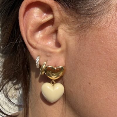 Boucles d'oreilles double coeur taupe portées, gros plan