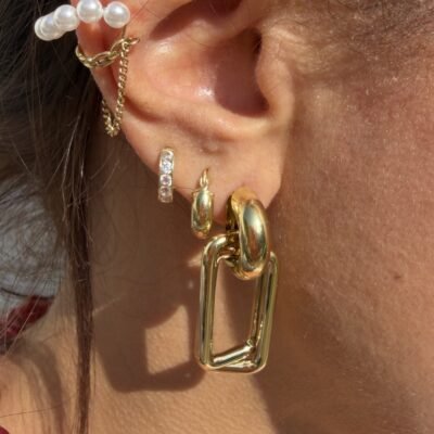 Boucles d'oreilles maillons rectangulaires dorées portées en accumulation