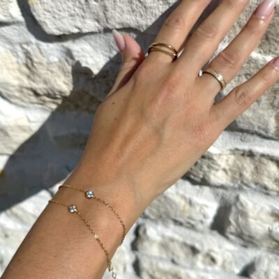 Bracelet double chaîne doré, gros plan des deux cristaux ronds