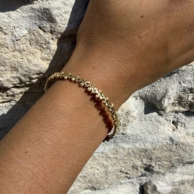 Bracelet fleurs doré porté au poignet, gros plan