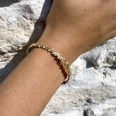 Bracelet fleurs doré porté au poignet, gros plan