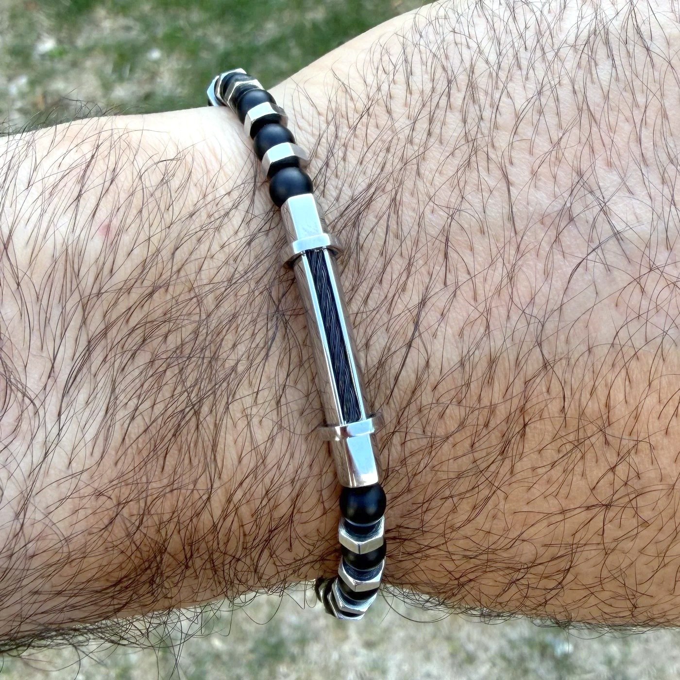 Bracelet Homme Perles Noires & Écrous Acier 3 Bracelet homme perles noires et écrous acier porté au poignet, tube en acier poli