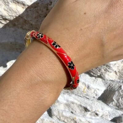 Jonc émaillé rouge fleurs noires en laiton doré porté