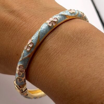 Bracelet jonc en laiton doré émaillé turquoise fleurs roses au poignet, vue rapprochée
