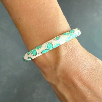 Bracelet jonc émaillé vert d'eau à fleurs porté au poignet, acier inoxydable doré