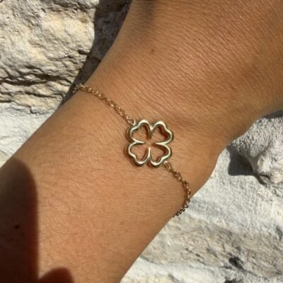 Bracelet trèfle creux doré porté au poignet