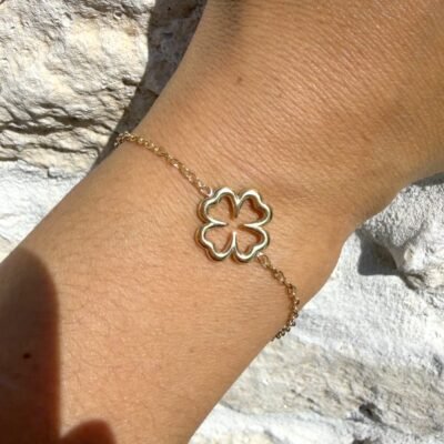 Bracelet trèfle creux doré porté au poignet