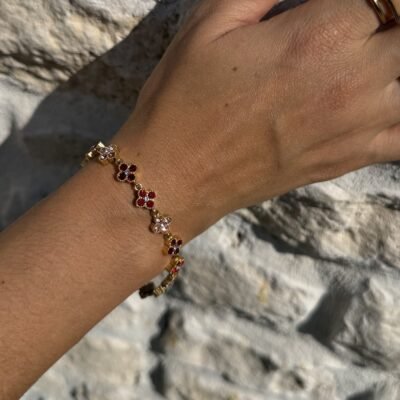 Bracelet trèfles dorés sertis de strass rouges et roses porté