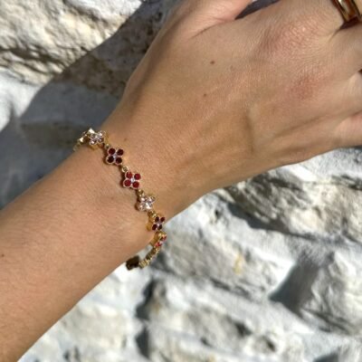 Bracelet trèfles dorés sertis de strass rouges et roses porté