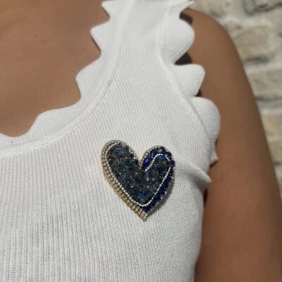 Broche cœur cristaux bleus portée sur un top blanc