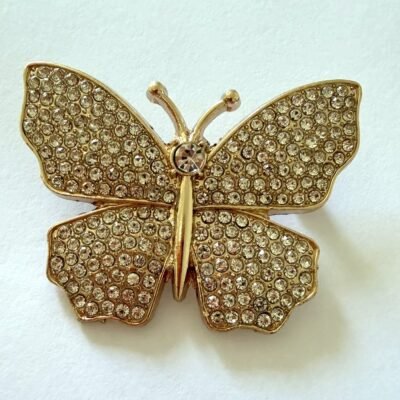 Broche papillon dorée aux ailes entièrement pavées de strass transparents, vue de face