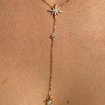 Gros plan sur l'étoile polaire pavée de strass du collier doré