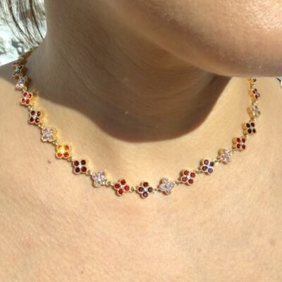 Collier rivière de trèfles dorés sertis de strass rouges et roses porté