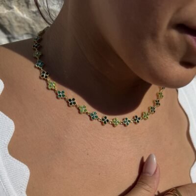 Collier trèfle vert doré porté avec un haut blanc
