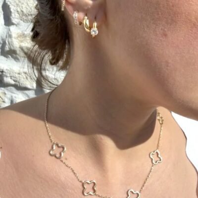 Collier trèfle doré porté avec créoles dorées