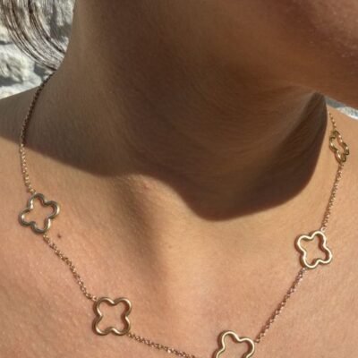 Collier trèfle doré ajouré porté en gros plan