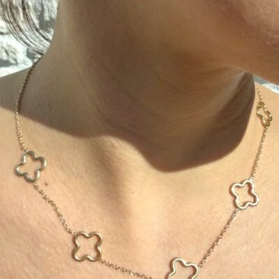 Collier trèfle doré ajouré porté en gros plan