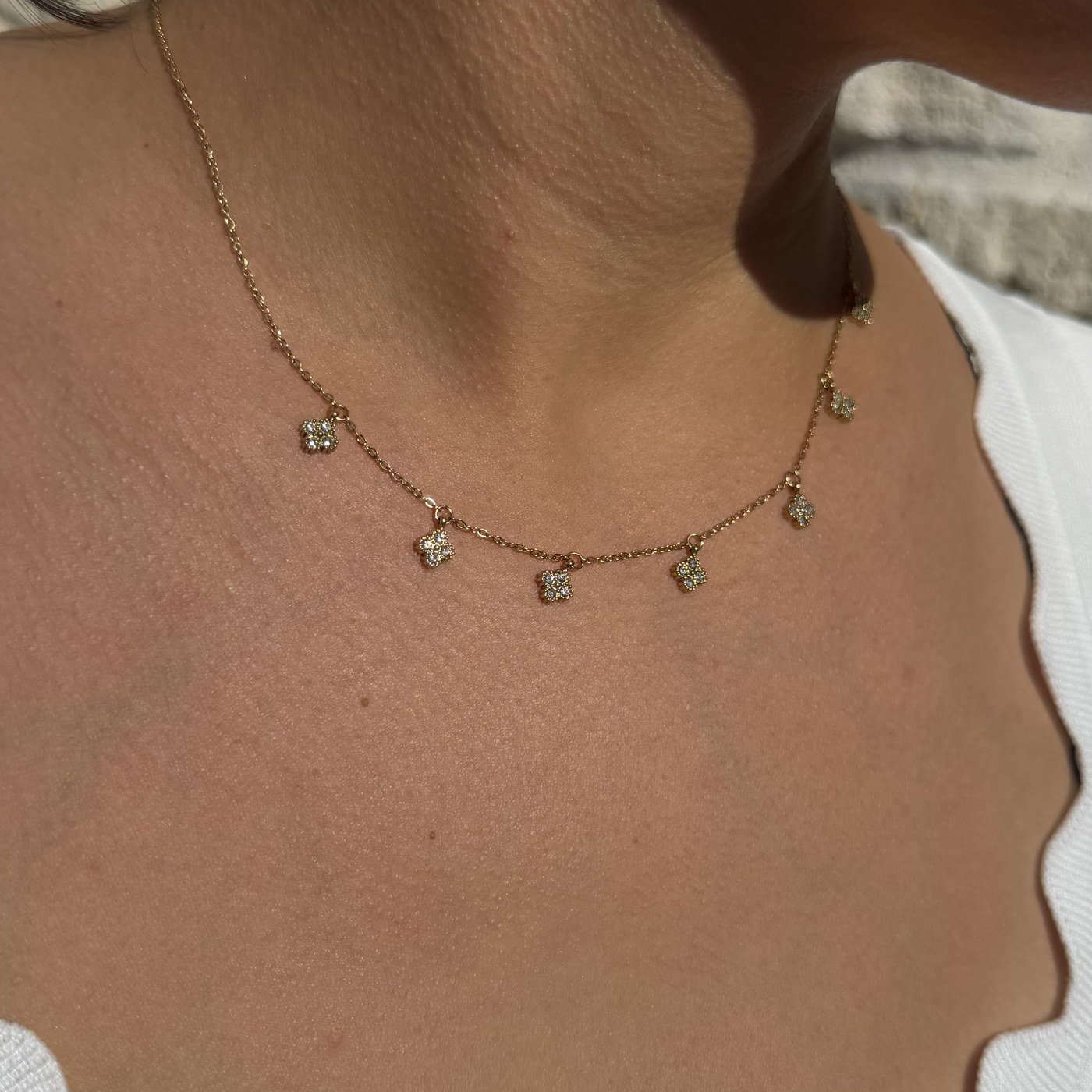 Collier Trèfles Strass Blancs à Pampilles Doré 1 Collier trèfles strass blancs doré à pampilles porté au cou