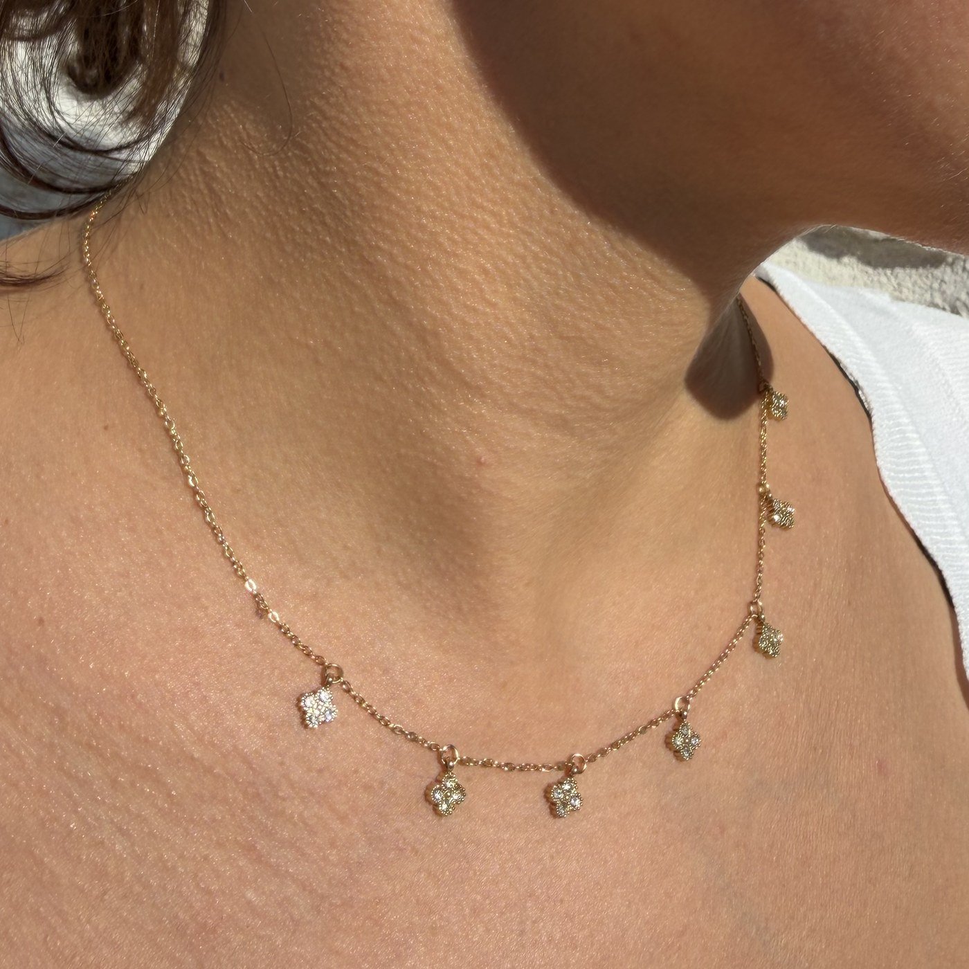 Collier Trèfles Strass Blancs à Pampilles Doré 5 Collier trèfles strass blancs doré porté sur le décolleté