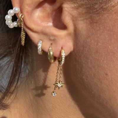 Créoles étoile polaire strass dorées portées en accumulation