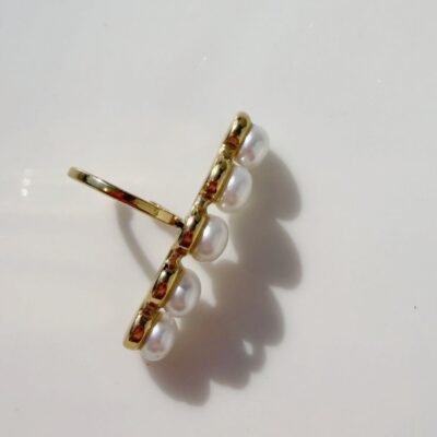 Ear cuff barrette perles dorée sur plateau blanc, anneau ouvert visible