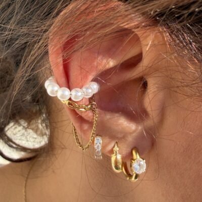 Ear cuff perles et chaîne dorée porté sur le haut de l'oreille avec des créoles