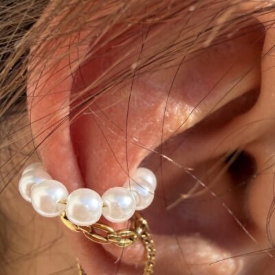 Gros plan sur l'ear cuff à perles nacrées et maillons dorés porté
