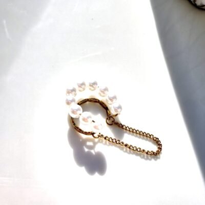 Ear cuff perles et chaîne dorée sur plateau blanc