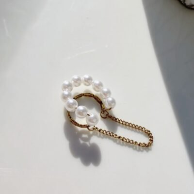 Ear cuff perles et chaîne dorée sur plateau blanc